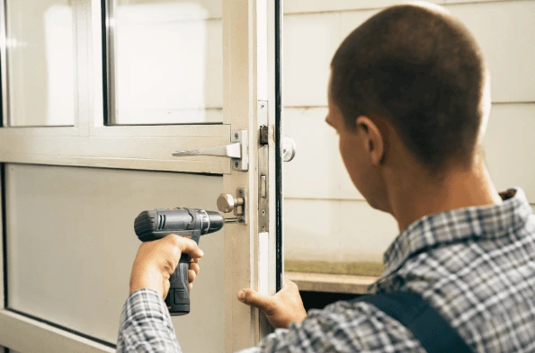 Technician servicing a door closer on a commercial entrance